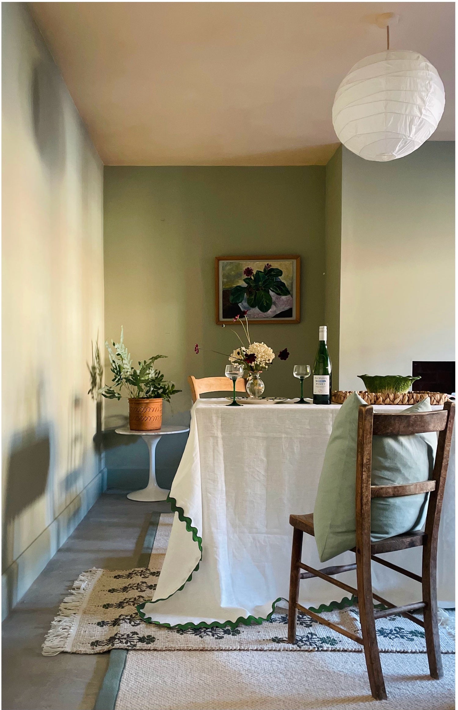 Dining room with a table set for a meal, featuring a bottle of wine and glasses.